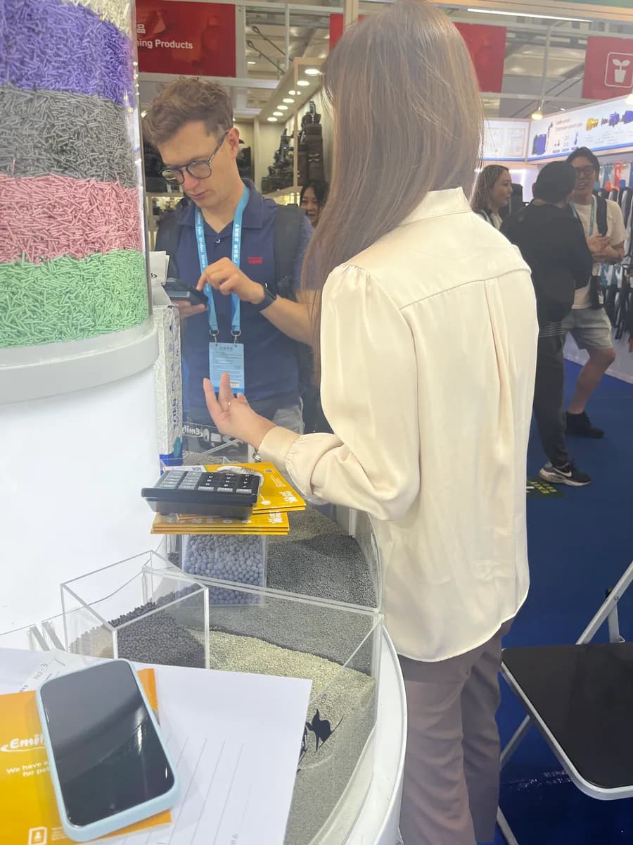 A visitor reviews different pet-product sample materials displayed at the Emily pets booth
