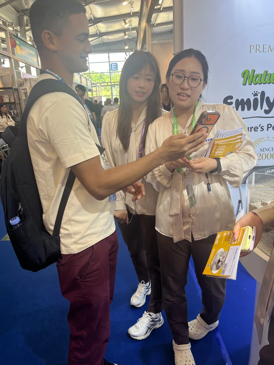 Emily pets team member sharing product information with a visitor at the Canton Fair booth