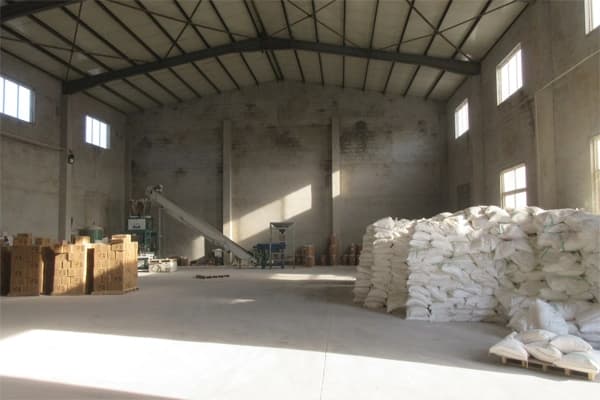 Packaging operator supervising finished pet litter cartons and quality checks